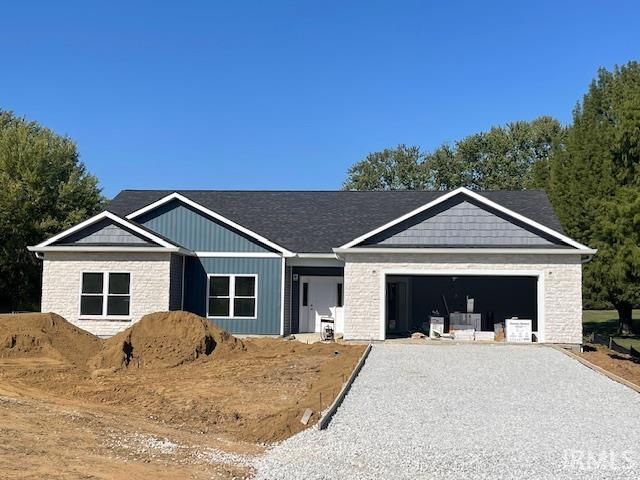 view of front of home with gravel driveway and a garage