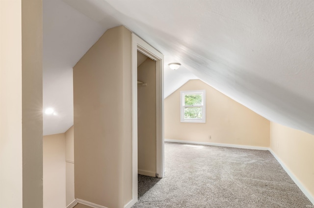 bonus room with vaulted ceiling and carpet floors