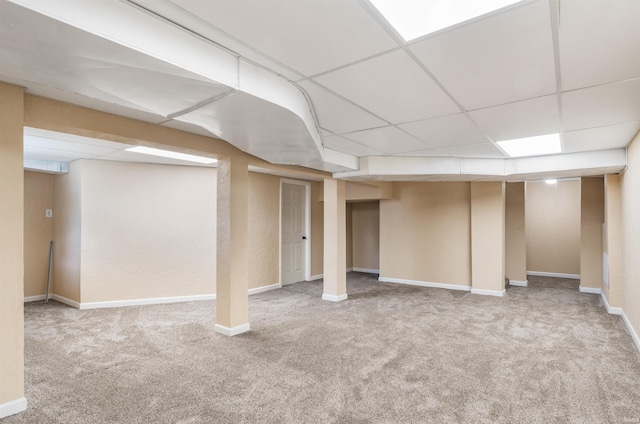 basement with carpet floors and a paneled ceiling