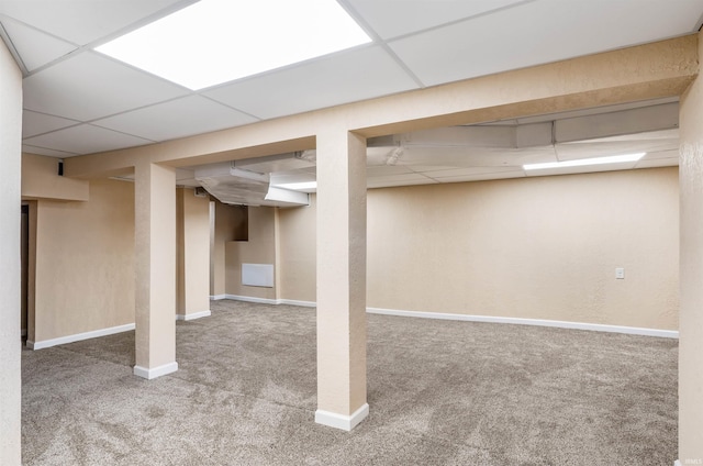 basement featuring carpet floors and a drop ceiling