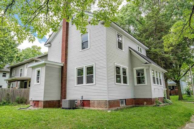 view of side of home featuring central AC and a yard