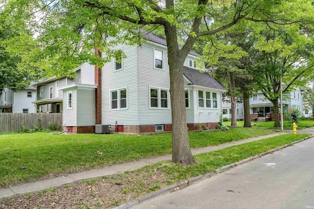 view of side of home featuring a lawn and central air condition unit