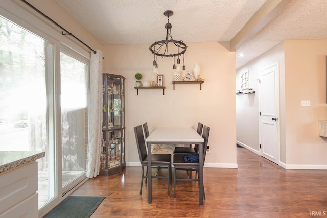 dining room featuring a textured ceiling and dark hardwood / wood-style floors