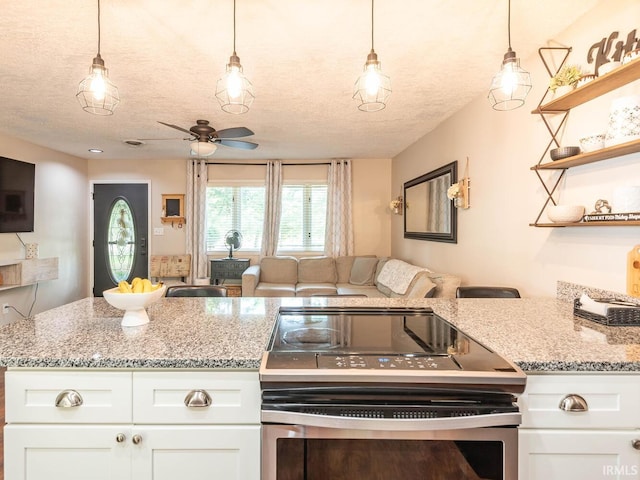 kitchen with white cabinets, stainless steel electric range oven, a textured ceiling, and pendant lighting