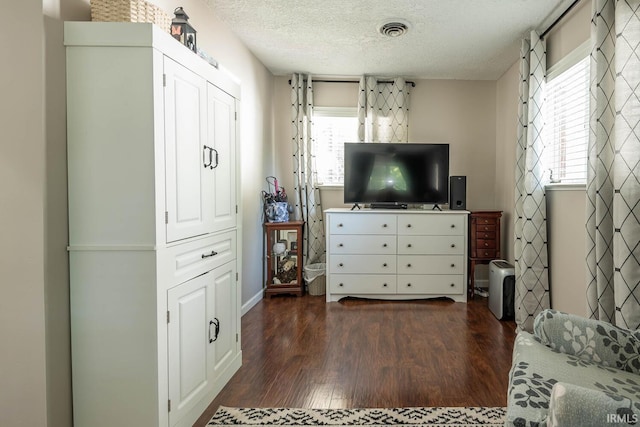 bedroom featuring a textured ceiling and dark hardwood / wood-style floors