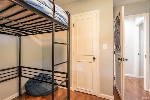 bedroom featuring a textured ceiling and dark hardwood / wood-style floors