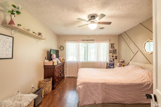 bedroom featuring a textured ceiling, ceiling fan, and dark hardwood / wood-style flooring