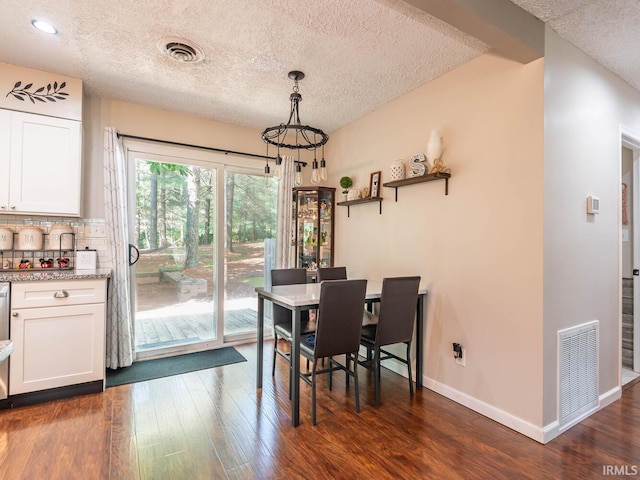 dining space with dark hardwood / wood-style flooring and a textured ceiling