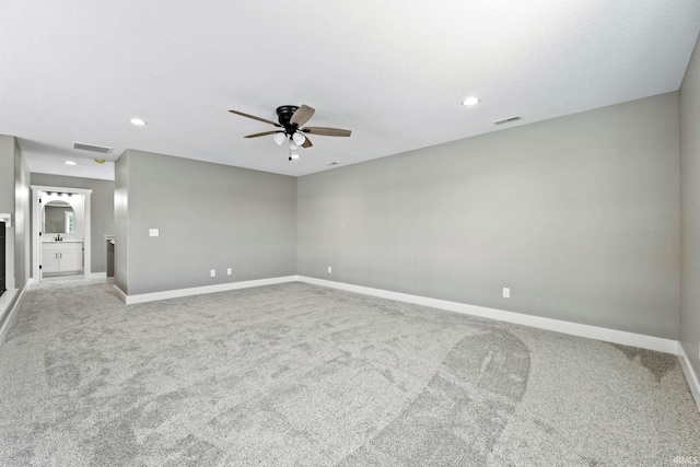 carpeted empty room with a ceiling fan, baseboards, visible vents, and recessed lighting