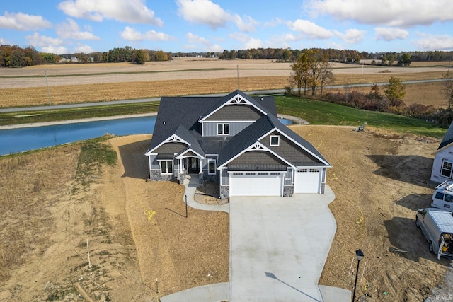 view of front of home with a rural view, a garage, and covered porch