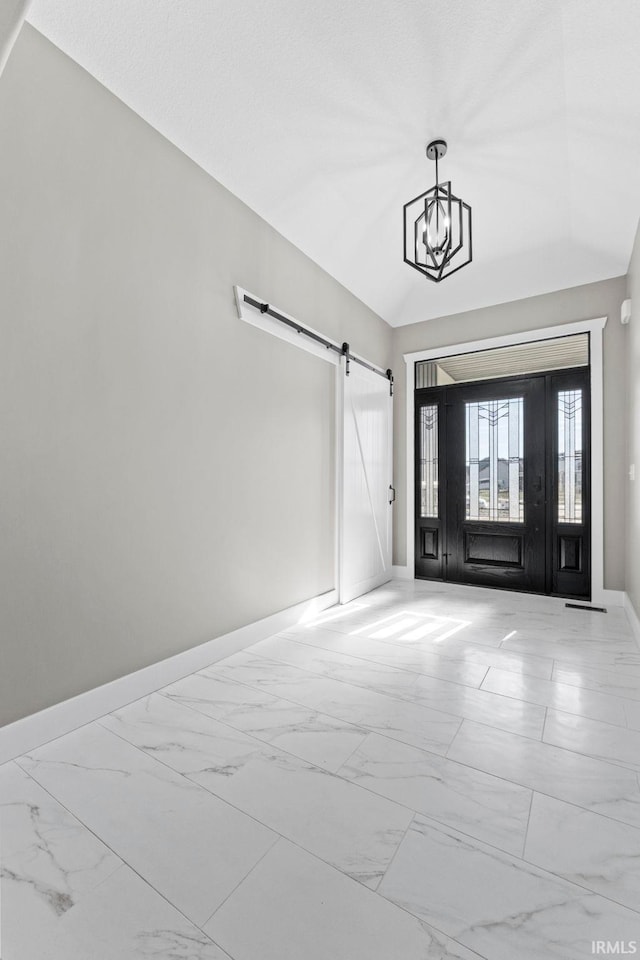 foyer with lofted ceiling, a barn door, and a chandelier