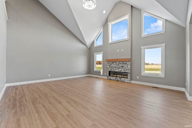 unfurnished living room featuring a fireplace, light hardwood / wood-style flooring, and a wealth of natural light