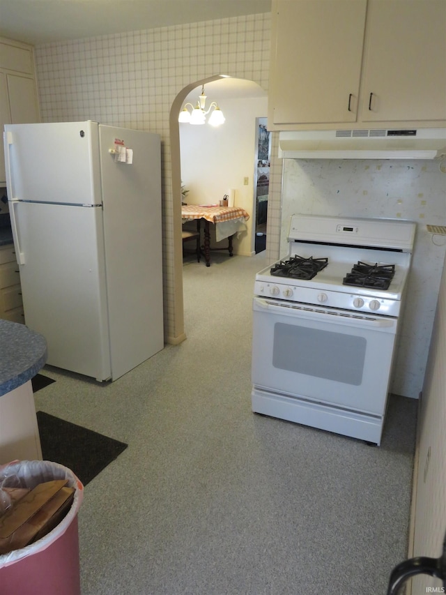 kitchen featuring a notable chandelier and white appliances