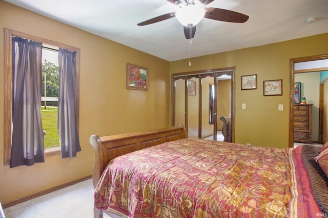 bedroom with ceiling fan, light colored carpet, and a closet