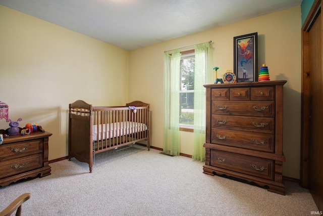 bedroom featuring light carpet and a crib