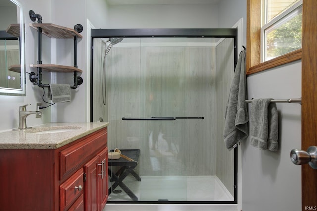 bathroom featuring vanity and a shower with shower door