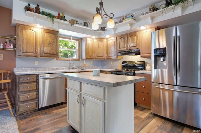 kitchen with stainless steel appliances, hardwood / wood-style flooring, a notable chandelier, a kitchen island, and hanging light fixtures