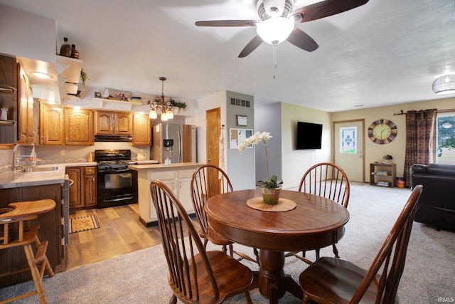 carpeted dining space featuring sink and ceiling fan with notable chandelier