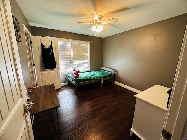 bedroom with dark wood-type flooring, a textured ceiling, and ceiling fan