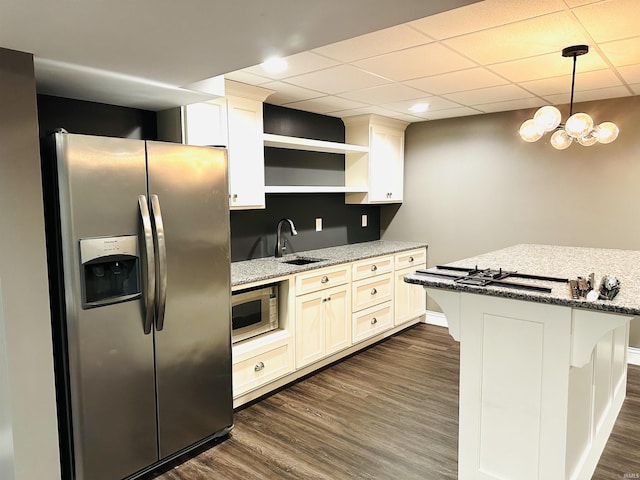 kitchen with pendant lighting, sink, dark hardwood / wood-style flooring, stainless steel appliances, and light stone countertops