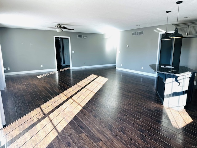 unfurnished living room featuring ceiling fan and dark hardwood / wood-style floors