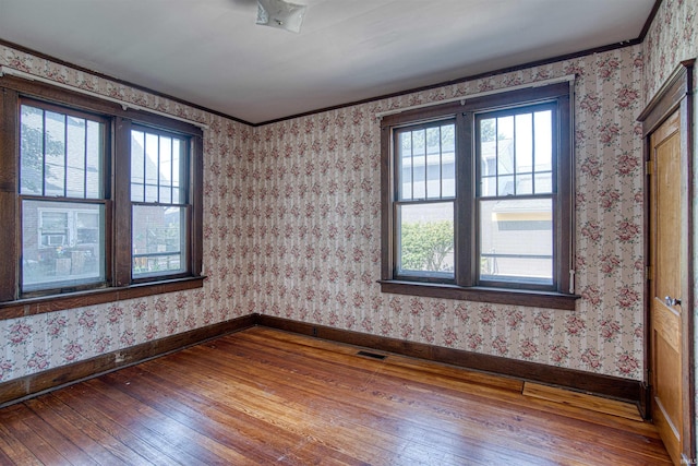 spare room with wood-type flooring and ornamental molding