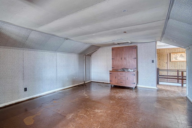 additional living space with wooden walls and lofted ceiling