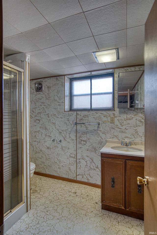 bathroom with a shower with door, vanity, and toilet