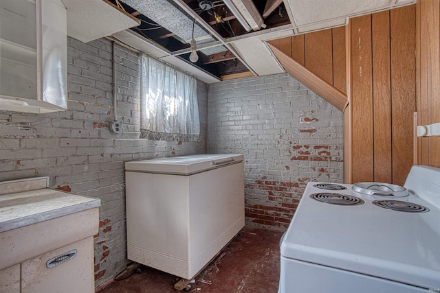 laundry room with brick wall