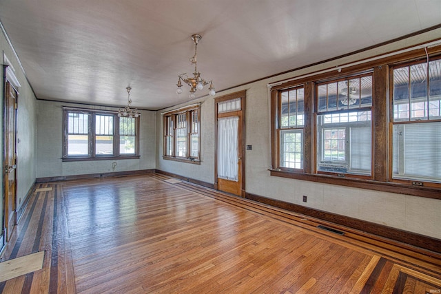 interior space with crown molding, hardwood / wood-style floors, and an inviting chandelier