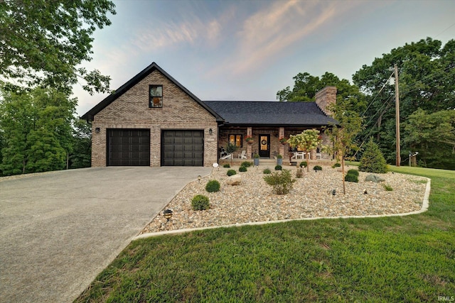 view of front of house featuring a garage, a front yard, and covered porch