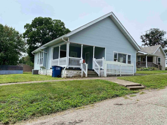 view of front of house featuring a porch, central air condition unit, and a front yard