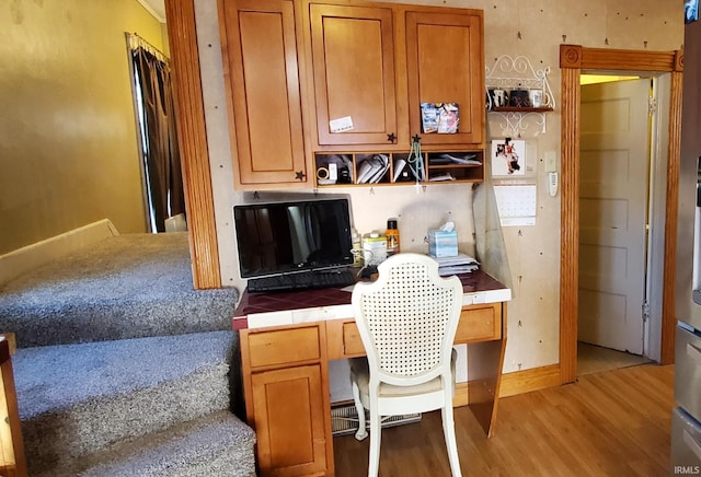 home office featuring built in desk and light wood-type flooring