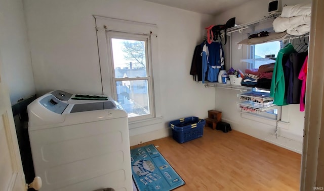 clothes washing area featuring washing machine and clothes dryer and hardwood / wood-style flooring