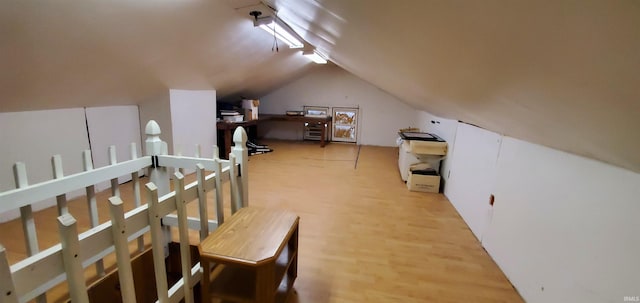 bonus room with lofted ceiling and hardwood / wood-style floors