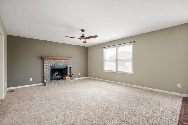 unfurnished living room with ceiling fan, carpet, and a fireplace