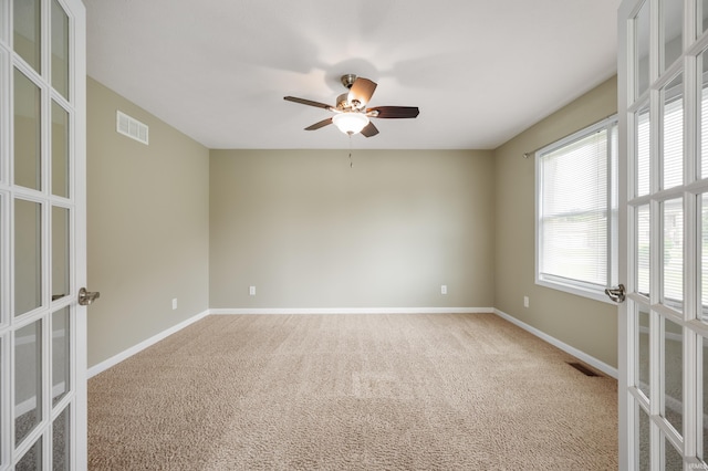 spare room featuring ceiling fan, french doors, and carpet