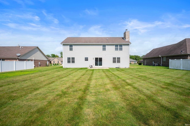 rear view of property featuring a lawn