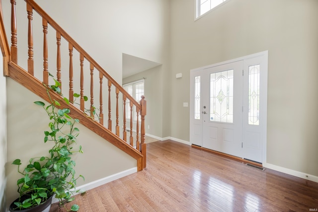 foyer entrance featuring a high ceiling and light wood-type flooring