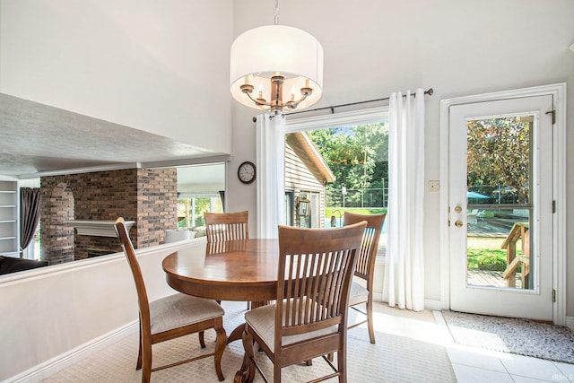 tiled dining room featuring a healthy amount of sunlight and a chandelier