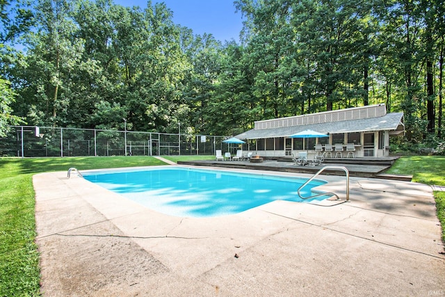 view of swimming pool featuring an outdoor bar, a patio, and a lawn