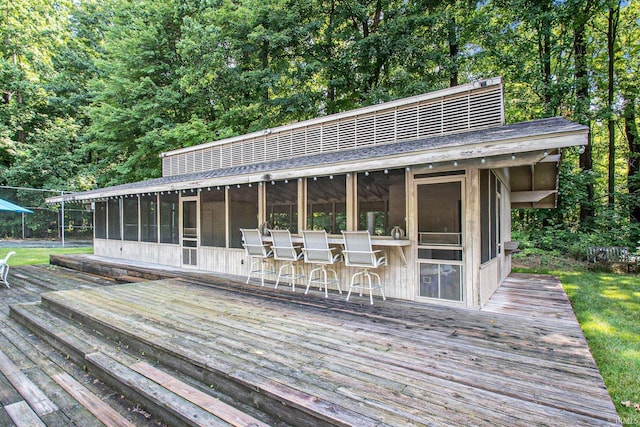 deck featuring a sunroom and an outdoor bar