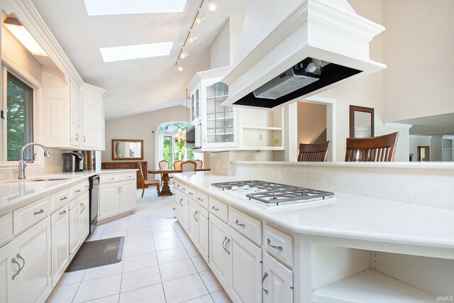 kitchen featuring white cabinetry, premium range hood, sink, and plenty of natural light