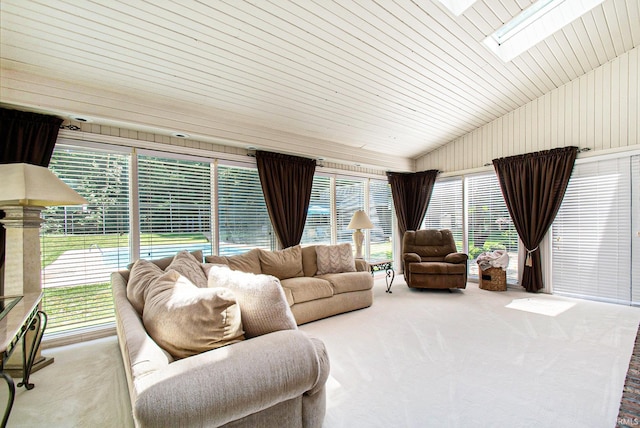 carpeted living room featuring lofted ceiling with skylight