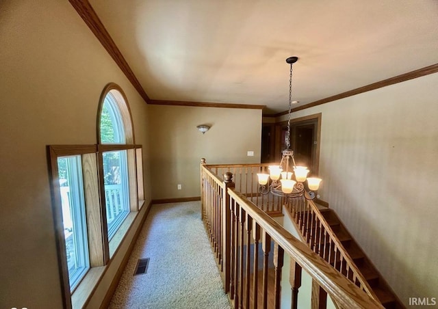 corridor featuring ornamental molding, carpet flooring, and a chandelier