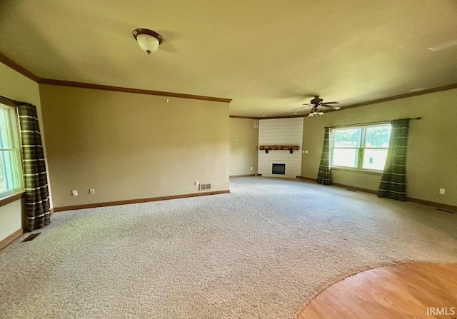 unfurnished living room featuring ceiling fan, carpet floors, and ornamental molding