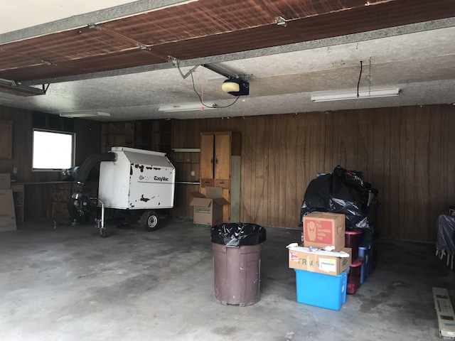 garage featuring a garage door opener and wood walls