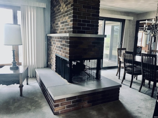 living room featuring a fireplace, carpet flooring, and a chandelier