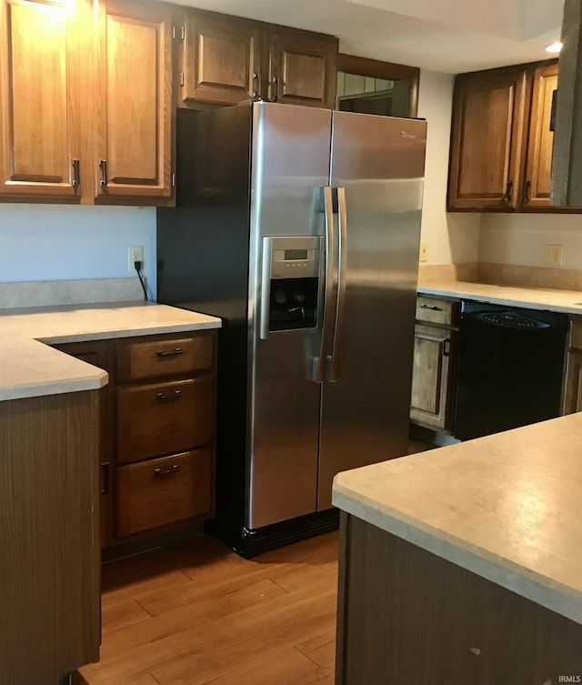 kitchen with stainless steel refrigerator with ice dispenser, dishwasher, and light wood-type flooring