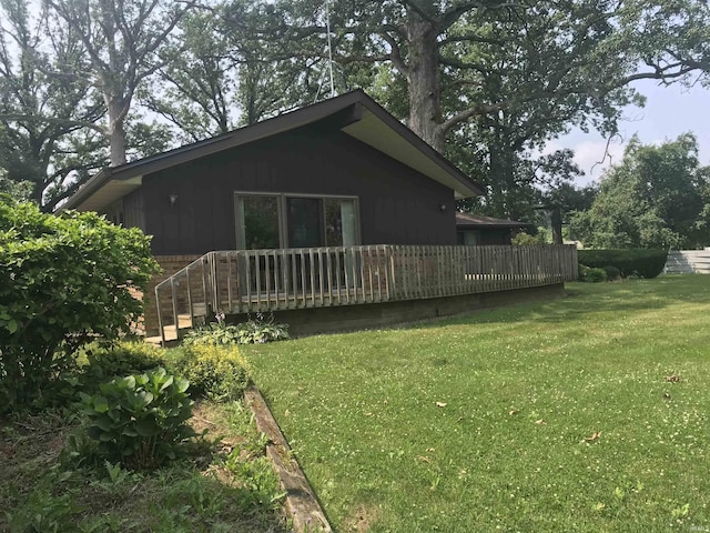 exterior space with a deck and a lawn